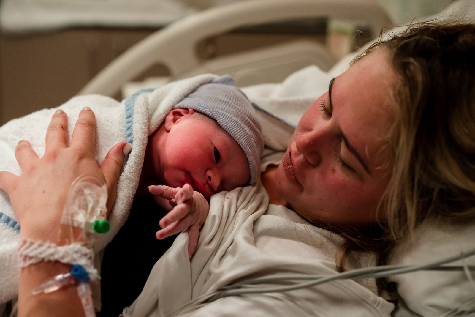 Mama ligt na de bevalling met haar pasgeboren zoon op haar borst