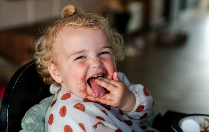 Meisje smeert haar hele gezicht onder met eten