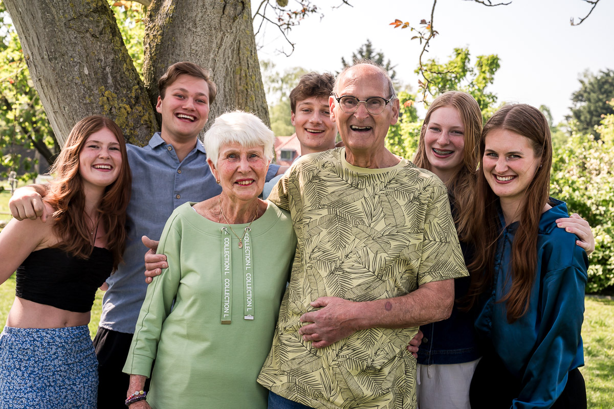 Opa en oma met hun kleikinderen op de foto tijdens een familieshoot in de tuin