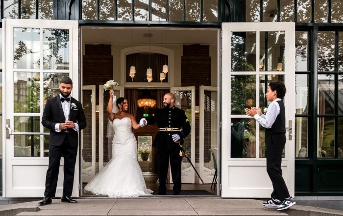 Het bruidspaar is getrouwd en komt juichend naar buiten bij Villa Clementine in Purmerend
