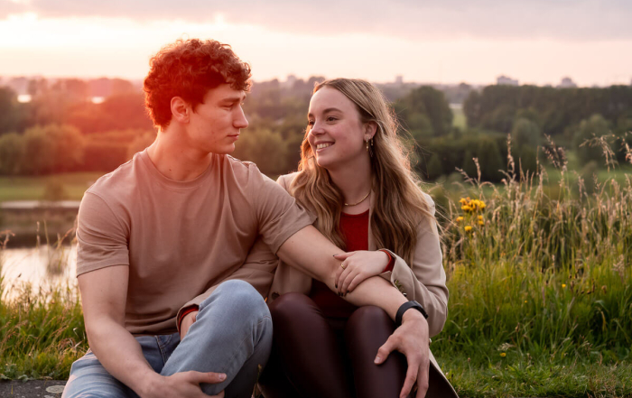 Bovenop de heuvel neemt het stel tijd voor elkaar tijdens de fotoshoot in Vijfhuizen